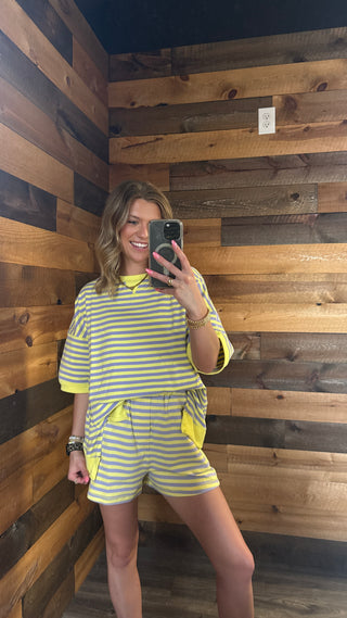 Person taking a mirror selfie against a wooden paneled wall.